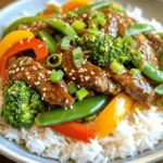 - 1 lb (450g) beef sirloin, thinly sliced - 2 tablespoons vegetable oil - 1 bell pepper (red or yellow), sliced - 1 cup broccoli florets - 1 cup snap peas - 2 cloves garlic, minced - 1 tablespoon fresh ginger, minced - 1/3 cup soy sauce - 1/4 cup honey - 2 tablespoons rice vinegar - 1 tablespoon cornstarch mixed with 2 tablespoons water (slurry) - 2 green onions, sliced (for garnish) - Sesame seeds (for garnish) You can switch out beef for other proteins. Chicken, tofu, or shrimp work well. Fresh veggies give the best taste, but frozen ones are fine too. If you need a gluten-free option, use gluten-free soy sauce for the same flavor. To start, heat a large skillet over medium-high heat. Add 1 tablespoon of vegetable oil. When the oil is hot, add the thinly sliced beef sirloin. I season the beef lightly with salt and pepper. Stir-fry the beef for about 3 to 4 minutes. You want it browned, but not overcooked. Once done, remove the beef from the skillet and set it aside. Seasoning adds flavor, so don’t skip this step! In the same skillet, add the remaining tablespoon of oil. Then, add 2 cloves of minced garlic and 1 tablespoon of minced ginger. Stir for about 30 seconds until they smell great. Next, add the sliced bell pepper, 1 cup of broccoli florets, and 1 cup of snap peas. Stir-fry these veggies for about 3 to 4 minutes. You want them tender but still crisp. This order helps cook the vegetables evenly. While the veggies cook, prepare the teriyaki sauce. In a small bowl, combine 1/3 cup of soy sauce, 1/4 cup of honey, and 2 tablespoons of rice vinegar. Whisk until everything is well mixed. Once the vegetables are ready, return the beef to the skillet. Pour the teriyaki sauce over the beef and veggies, stirring to coat everything. Now, make the sauce thick. Add 1 tablespoon of cornstarch mixed with 2 tablespoons of water. Stir continuously for about 1 to 2 minutes. This will help your sauce thicken up nicely. After that, you are ready to serve! - Using high heat for stir-frying: High heat is key. It helps cook the beef fast, keeping it tender. Heat your skillet until it’s hot. This way, the beef sears and caramelizes well. A hot skillet gives your dish that nice, smoky flavor. - Importance of not overcrowding the skillet: Avoid overcrowding your skillet. If you add too much beef or veggies, they will steam instead of fry. This makes them soggy. Cook in batches if needed. Give each piece room to brown nicely. This simple step makes a big difference! - Marinating beef for extra flavor: For extra flavor, marinate the beef. Use soy sauce, honey, and a splash of vinegar. Let it sit for at least 30 minutes. This step adds depth and richness to each bite. You can also add garlic or ginger to the marinade. - Alternative sauces for variation: Mix it up with different sauces! Instead of teriyaki, try hoisin or oyster sauce. You can also use a mix of soy sauce and lime juice for a tangy twist. Each sauce brings its own unique taste to your stir-fry. Be creative and find your favorite! {{image_2}} You can easily adjust this recipe to fit your diet. For a vegetarian or vegan version, swap the beef for tofu or tempeh. Both options soak up flavors well. Simply cut the tofu into cubes, and stir-fry it until golden. For a low-carb alternative, consider using cauliflower rice instead of regular rice. This adds a tasty crunch while keeping carbs lower. You can also load up on the veggies for more fiber and volume. Want to make your stir fry even better? You can add nuts like cashews or peanuts for crunch. Just toss them in during the last few minutes of cooking. You can also mix in other vegetables. Try carrots, mushrooms, or zucchini for added color and taste. For more flavor, experiment with different sauces or spices. A splash of sriracha can add heat, while a dash of sesame oil gives a nutty aroma. Each addition can make your dish unique and fun! To keep your Sweet Teriyaki Beef Stir Fry fresh, use airtight containers. Glass or plastic containers work well. Make sure to let the dish cool before sealing it. Store leftovers in the fridge for up to three days. If you want to keep them longer, freeze the stir fry. It can last for up to three months in the freezer. Just remember to label the containers with the date. When you’re ready to enjoy your leftovers, the best way to reheat is on the stove. Heat a non-stick skillet over medium heat. Add a splash of water or broth to keep it moist. Stir gently to warm everything evenly. If you prefer the microwave, use a microwave-safe dish. Cover it with a lid or wrap to prevent splatters. Heat in short bursts, stirring between each. To avoid sogginess, don’t add too much liquid. Enjoy your tasty meal again! What can I use instead of beef in this recipe? You can use chicken, shrimp, or tofu. Each option gives a new taste. Chicken is lean and works well. Shrimp cooks fast and adds a nice texture. Tofu is great for a plant-based meal. Just keep the cooking times in mind. Can I make this dish ahead of time? Yes, you can prep the beef and veggies in advance. Store them in the fridge. It’s best to cook the stir fry fresh. This keeps the veggies crisp and the beef tender. If you must make it ahead, reheat gently. How do I make the sauce thicker or thinner? To thicken the sauce, add more cornstarch slurry. Mix one tablespoon of cornstarch with two tablespoons of water. Stir this into the sauce while it cooks. For a thinner sauce, add more soy sauce or water. Adjust it to your liking. What side dishes pair best with Sweet Teriyaki Beef Stir Fry? Steamed jasmine rice or quinoa work great. They soak up the sauce well. You can also serve it with a fresh salad or steamed veggies. For a fun touch, use chopsticks to eat! In this article, we explored the ingredients needed for a tasty Sweet Teriyaki Beef Stir Fry. You learned about required items like beef sirloin, colorful veggies, and flavor boosters. We also discussed cooking steps and helpful tips for the best results. Final thoughts: Cooking is fun and you can adjust this dish to fit anyone’s taste. Whether you like beef, chicken, or tofu, this stir fry is sure to please everyone!