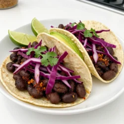For these tasty tacos, you need simple ingredients. Here’s what you’ll use: - 2 cups canned black beans, rinsed and drained - 1 tablespoon olive oil - 1 small red onion, finely chopped - 2 garlic cloves, minced - 1 teaspoon ground cumin - 1 teaspoon smoked paprika - ½ teaspoon cayenne pepper (adjust to taste) - Salt and pepper to taste - 8 small corn tortillas These main ingredients bring great flavor to your tacos. The black beans are hearty and healthy. The spices add warmth and depth. You can make your tacos even better with these toppings: - 1 cup shredded red cabbage - ½ cup fresh cilantro, chopped - 1 avocado, sliced - Lime wedges for serving - Hot sauce (optional) These extras add crunch and freshness. Avocado makes it creamy, while lime gives a zesty kick. To make these tacos, you will need a few basic tools: - Medium-sized skillet - Spatula - Fork - Another skillet for warming tortillas - Serving plates Having the right tools makes cooking easy and fun. You will enjoy making these street tacos in no time! {{ingredient_image_1}} Start by heating one tablespoon of olive oil in a medium skillet over medium heat. Add one small red onion, finely chopped. Sauté it for about three to four minutes until it turns soft and clear. Next, add two minced garlic cloves and cook for one more minute. This step brings out the sweet and rich flavors of the garlic. Now, stir in the beans. Use two cups of canned black beans that you rinsed and drained. Add one teaspoon of ground cumin, one teaspoon of smoked paprika, and half a teaspoon of cayenne pepper. You can adjust the cayenne to match your taste. Season with salt and pepper. Cook this mixture for five to seven minutes. This allows the beans to heat up and soak in the spices. Use a fork to mash some beans, but keep a few whole for texture. While your beans cook, it’s time to warm the tortillas. Take eight small corn tortillas and place them in another skillet over medium heat. Warm each side for about thirty seconds. You want them warm and soft, so they’re easy to fold. Now that your beans and tortillas are ready, it’s time to assemble the tacos. Place a generous spoonful of the spicy black bean mixture on each tortilla. Next, top them with one cup of shredded red cabbage. Add half a cup of fresh cilantro for a burst of flavor. Finally, include slices of one avocado on top. Serve your tacos with lime wedges on the side. You can also drizzle some hot sauce if you like it spicy. Enjoy your vibrant and tasty tacos! To change the spice level, you can adjust the cayenne pepper amount. If you like it spicier, add more. For less heat, use less cayenne or skip it entirely. You can also add hot sauce at the end. Taste as you go. This helps you find your perfect heat. Warm corn tortillas on medium heat in a skillet. Cook them for about 30 seconds on each side. This makes them soft and easy to fold. If you want, cover them with a clean towel after warming. This keeps them warm and fresh for longer. When mashing black beans, use a fork or a potato masher. Mash slightly to keep some beans whole. This gives great texture to your tacos. Be gentle; you want a mix of creamy and whole beans. Use a little olive oil if they seem too dry. Pro Tips Adjust Heat Level: If you prefer less spice, reduce the cayenne pepper or omit it altogether. You can always add hot sauce later for those who like it spicy. Fresh Ingredients Matter: Use fresh cilantro and ripe avocados for the best flavor and texture. Fresh ingredients elevate the entire dish. Keep Tortillas Warm: Place a clean kitchen towel over the tortillas as you warm them to keep them pliable and prevent them from drying out. Customize Toppings: Feel free to add your favorite toppings such as diced tomatoes, jalapeños, or a dollop of sour cream for extra creaminess and flavor. {{image_2}} You can easily make these tacos vegetarian or vegan. The black beans are already plant-based. Use olive oil for cooking, and all toppings are vegan. For a richer flavor, add nutritional yeast to the black bean mix. This adds a cheesy taste without any dairy. Feel free to swap ingredients based on your taste. Use pinto beans instead of black beans for a different texture. You can also add corn for sweetness. If you want more heat, try adding jalapeños or a spicier hot sauce. For a smoky flavor, consider using chipotle powder instead of smoked paprika. These tacos pair well with many sides. Serve with a fresh salad or guacamole for a tasty meal. A side of rice makes it more filling. You can also serve a cool drink, like agua fresca or a lime soda. For fun, set up a taco bar with various toppings so everyone can customize their tacos. After you make these spicy black bean street tacos, you might have leftovers. To keep them fresh, store the tacos in an airtight container. Place them in the fridge. They will stay good for about 2-3 days. If your tacos are assembled, the toppings might get soggy. To prevent this, store the filling and toppings separately. If you want to keep tacos longer, freezing is a great option. First, let the black bean mixture cool completely. Then, place it in a freezer-safe bag. Squeeze out as much air as possible before sealing. You can freeze the black bean mixture for up to 3 months. To reheat, thaw it overnight in the fridge. Heat in a skillet over medium heat until warm. Warm the tortillas separately before serving. The ingredients you use have different shelf lives. Here are some key points: - Black beans: Canned black beans last about 3-5 years if unopened. Once opened, keep them in the fridge for 3-4 days. - Red onion: Whole onions last about 1-2 months in a cool, dark place. Once chopped, use them within 7-10 days. - Garlic: Fresh garlic can last up to 3 months in a cool area. Once minced, use it within a week. - Corn tortillas: Unopened tortillas can last 2-4 months in the pantry. Once opened, use them within a week for best taste. Yes, you can use other beans! Pinto beans or kidney beans work well. They add a nice flavor and texture. Just make sure you rinse and drain them the same way. You can even mix different beans for more taste. Experimenting can lead to fun new flavors. The best toppings for black bean tacos include: - Shredded red cabbage - Fresh cilantro - Sliced avocado - Diced tomatoes - Crumbled cheese or vegan cheese - Lime wedges - Hot sauce These toppings add crunch, creaminess, and brightness to your tacos. Feel free to get creative with your favorites! To make this recipe gluten-free, use corn tortillas. Most corn tortillas are naturally gluten-free. Always check the label to be sure. You can also use gluten-free wraps if you prefer. Enjoy your meal without worry! You learned how to make spicy black bean street tacos. We covered main ingredients, optional toppings, and cooking tools. I shared step-by-step instructions for preparing, warming, and assembling the tacos. You now have tips to adjust spice levels and ensure perfect tortillas. Variations allow for veggie swaps and fun pairings. Lastly, you know how to store leftovers and keep them fresh. Enjoy making these tasty tacos again and again!